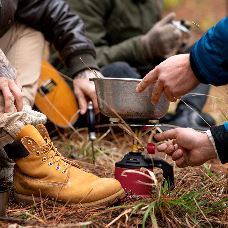 People cooking together around a campfire