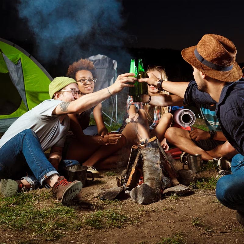 Friends toasting around a campfire at night